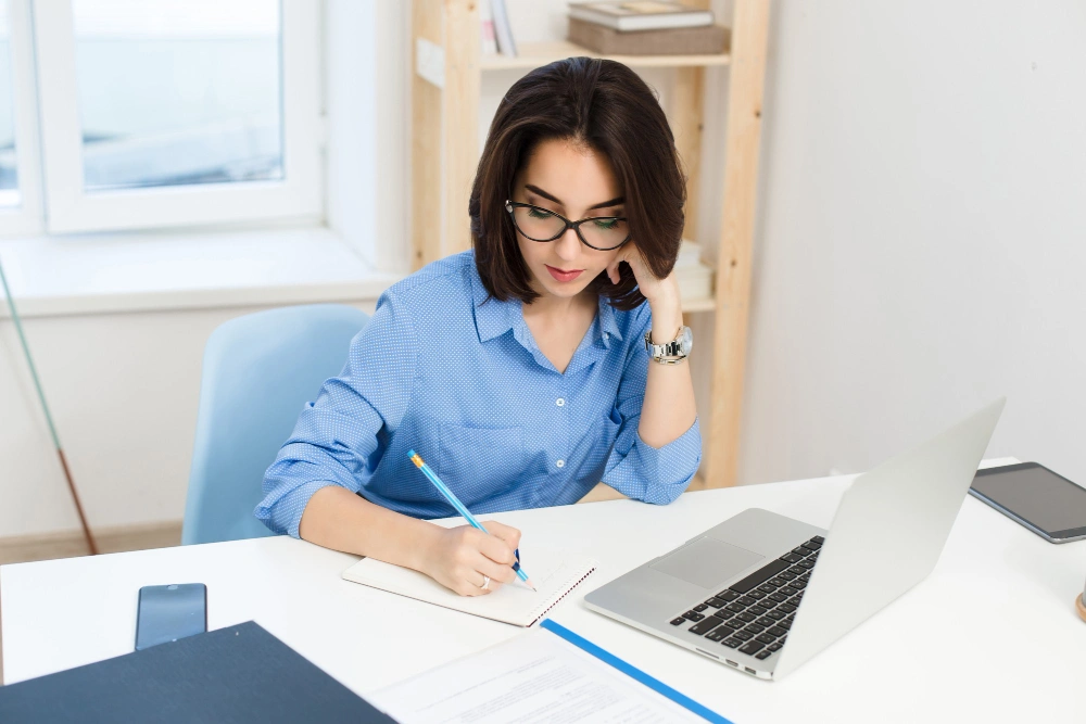 Woman entrepreneur working on business plans and applying for Atomic Grants at her desk