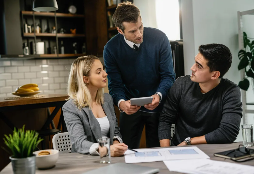 Three professionals gathered around a table reviewing documents, illustrating the concept of “Which Grants Are Not Taxable.”