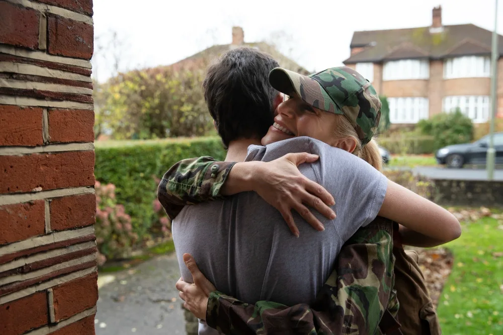 U.S. Army service member standing with spouse and children receiving AFAS Gas Grant support for gas and transportation needs.