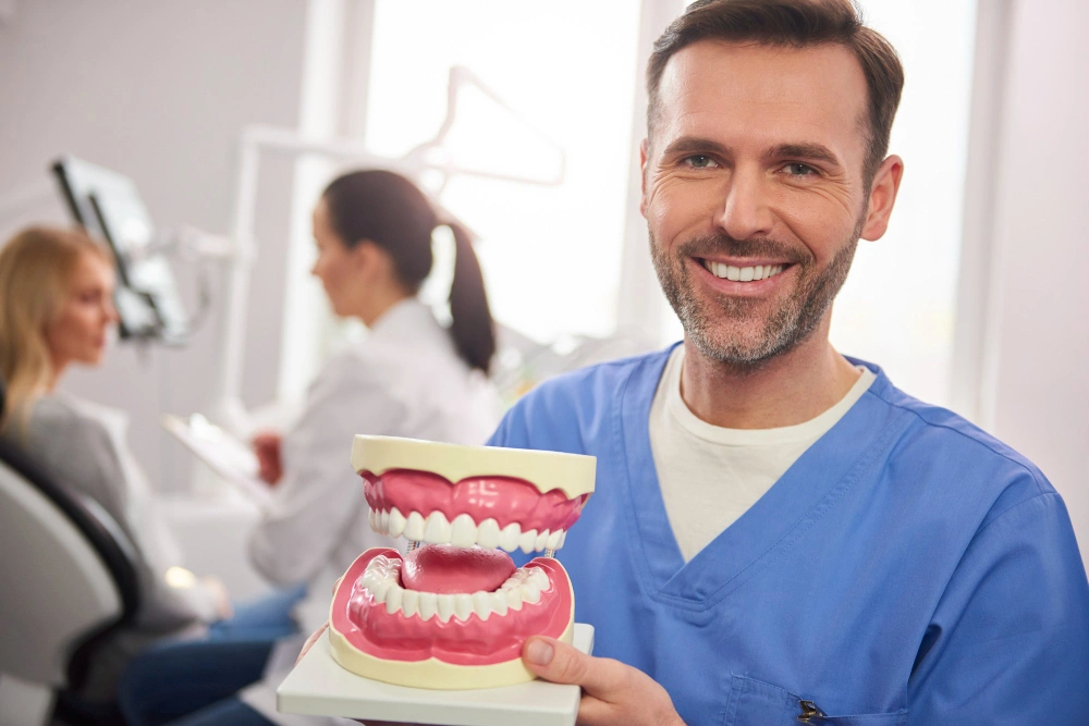 Grants for Dental Implants in California image of doctor holding artificial teeth