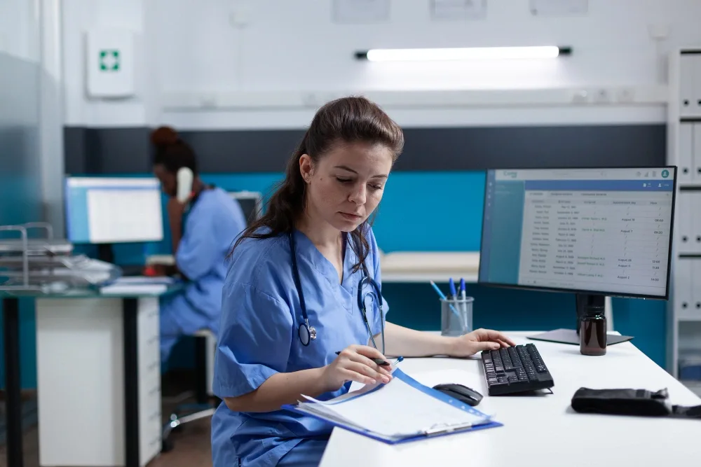 Healthcare administration student reviewing medical coding charts and certification materials funded through grants for medical billing and coding.